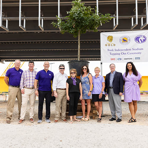 donors standing in front of signatures beam