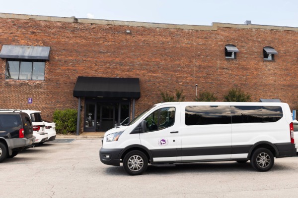 UNA shuttle van in front of the bus stop at the McKinney Center
